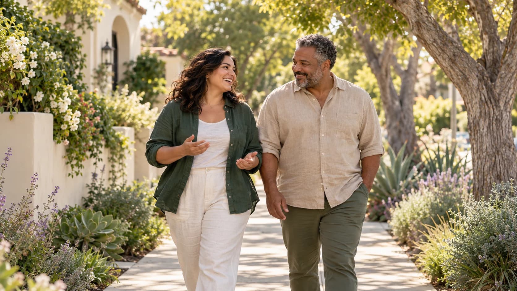 A woman and a man chatting on a sunny neighborhood walk.